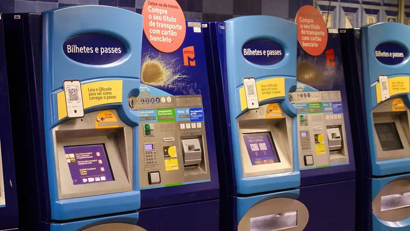 A row of blue ticket machines labelled “Bilhetes e passes” in a Lisbon Metro station.